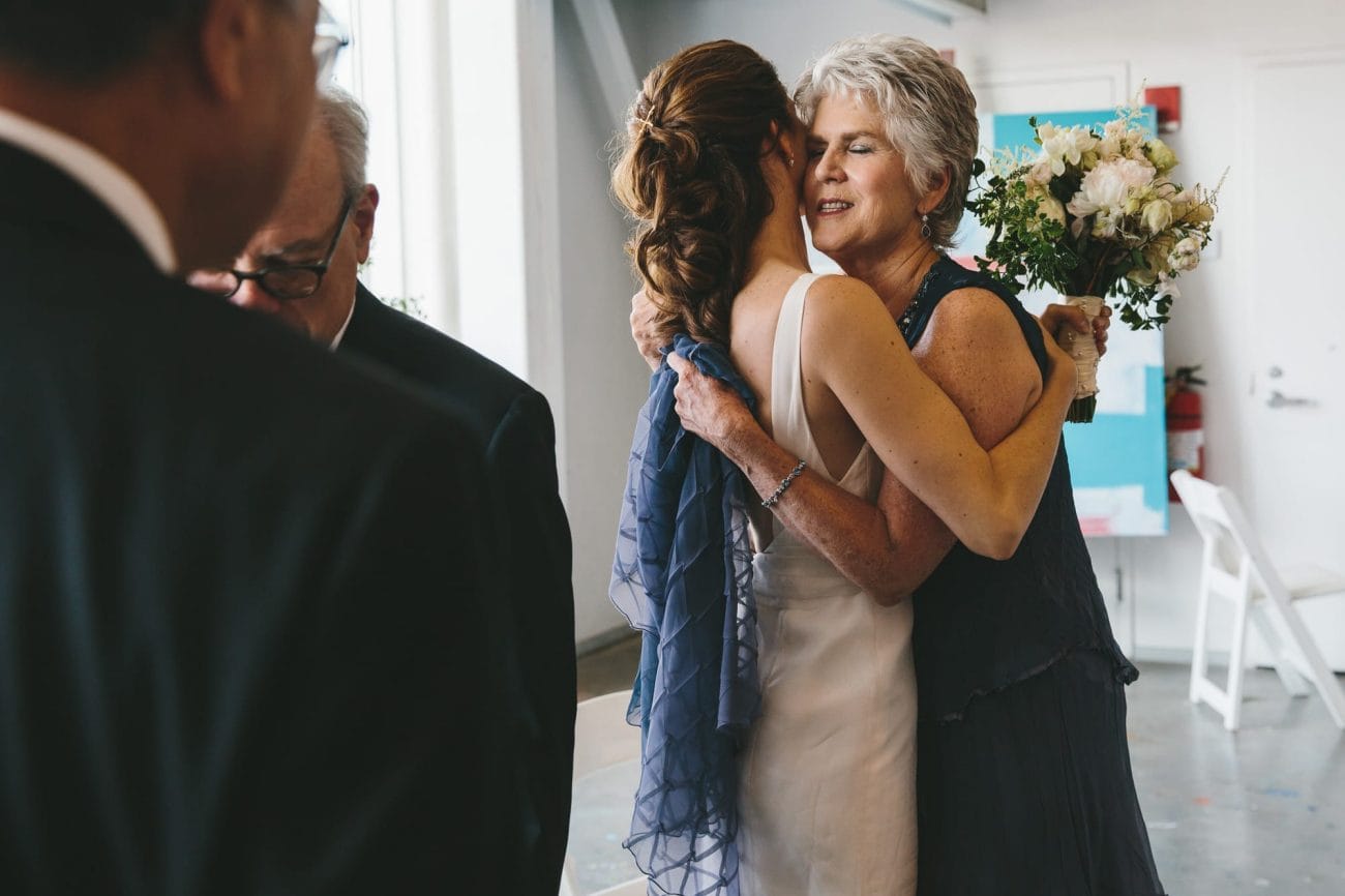 A documentary photograph of a bride hugging her mother during an Artists for Humanity Wedding in Boston