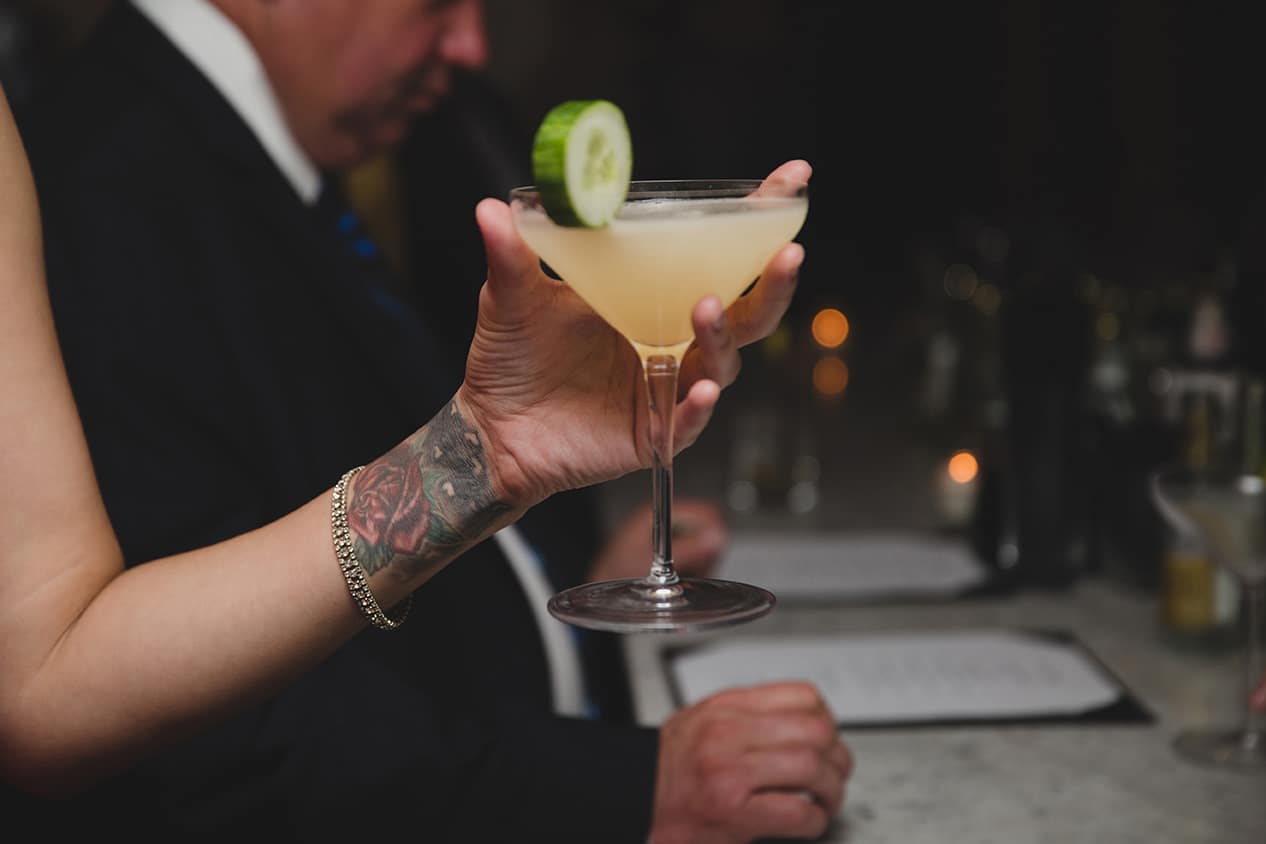 A documentary photograph of a guest picking up a cocktail during a Marliave wedding reception in Boston, Massachusetts