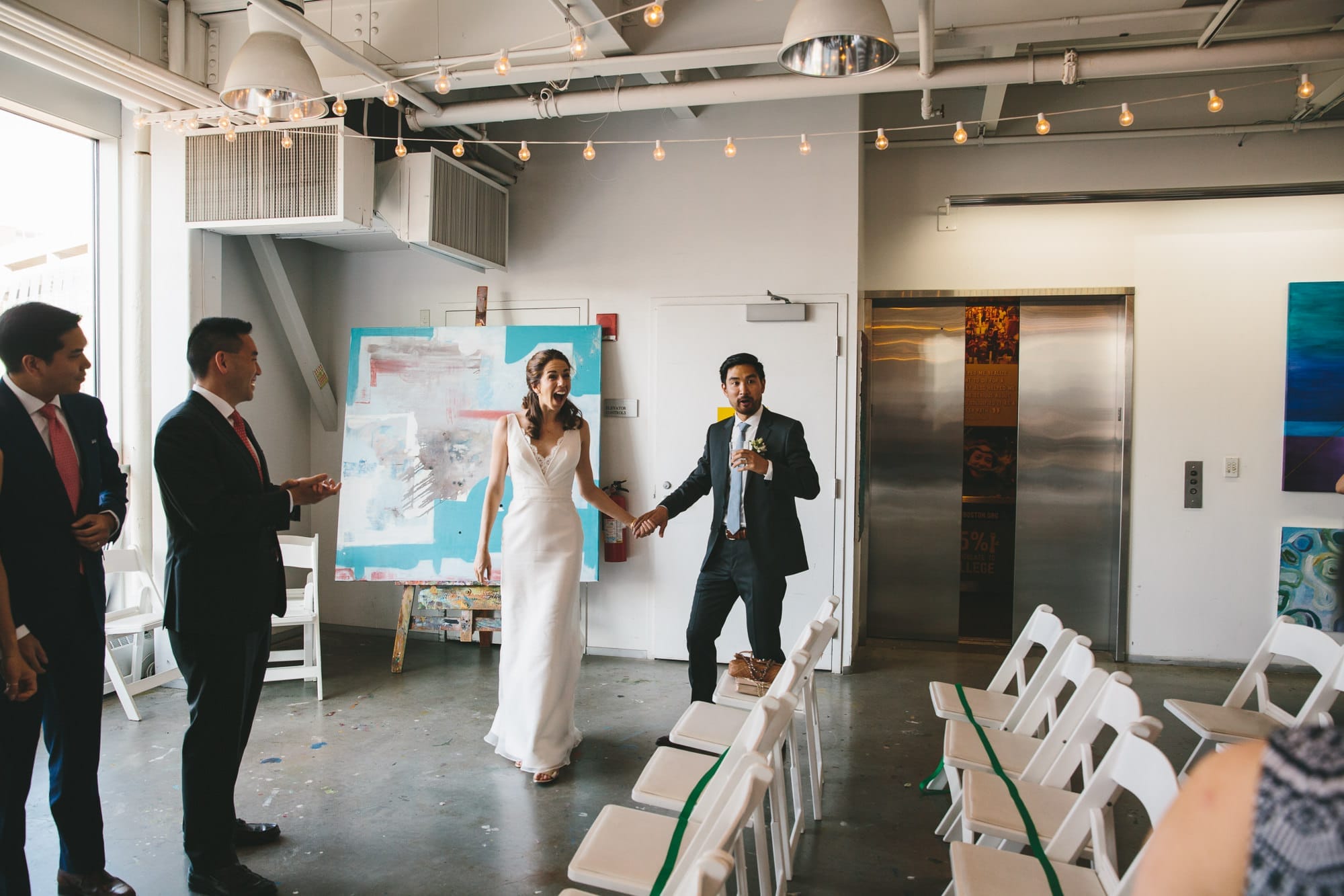 A documentary photograph of a bride and groom seeing their guests during their Artists for Humanity Wedding in Boston