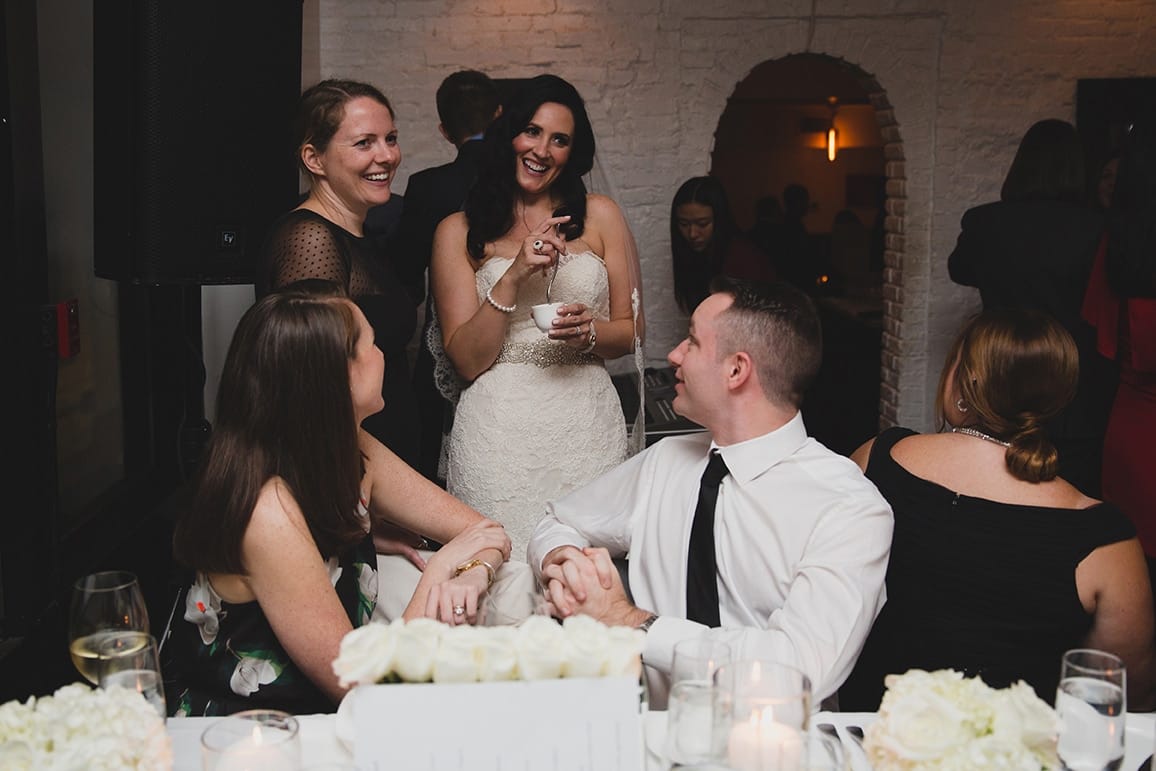 A documentary photograph of a bride talking with friends during her Marliave wedding reception in Boston, Massachusetts