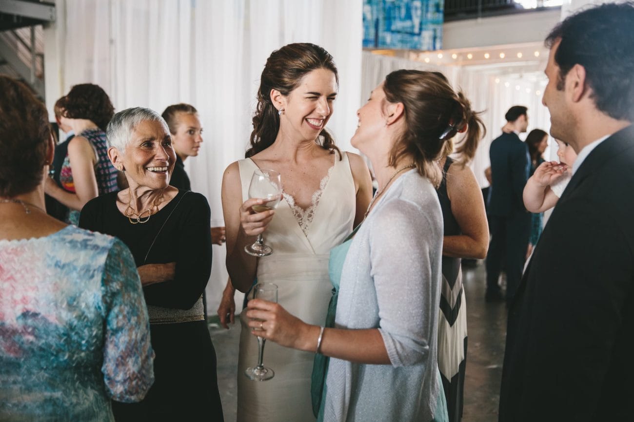 A documentary photograph of a bride talking to her guests during an Artists for Humanity Wedding in Boston