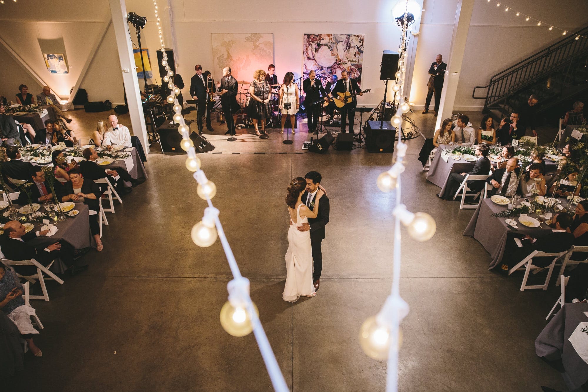 A documentary photograph of a bride and groom sharing their first dance during their Artists for Humanity Wedding