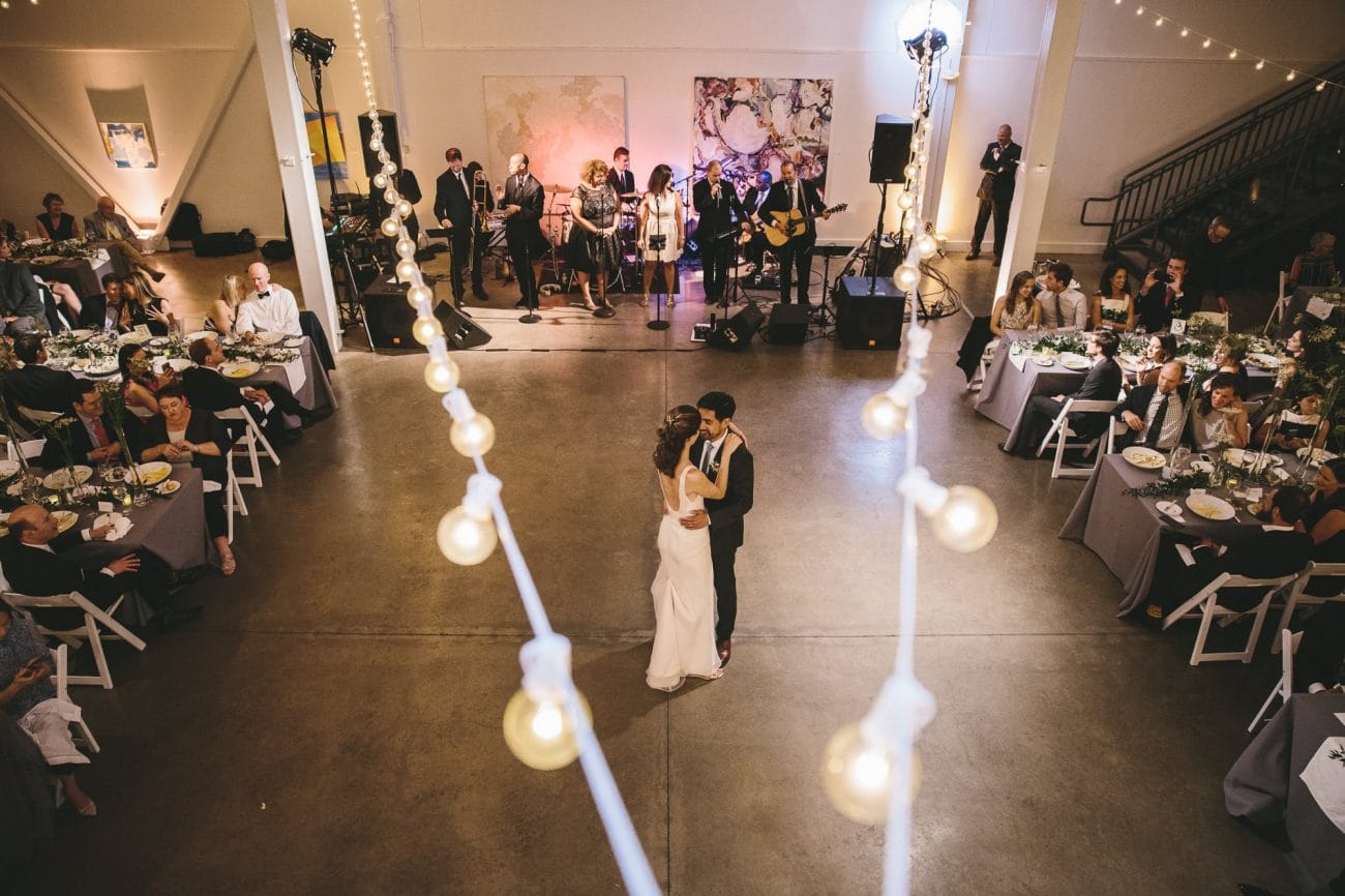 A documentary photograph of a bride and groom sharing their first dance during their Artists for Humanity Wedding