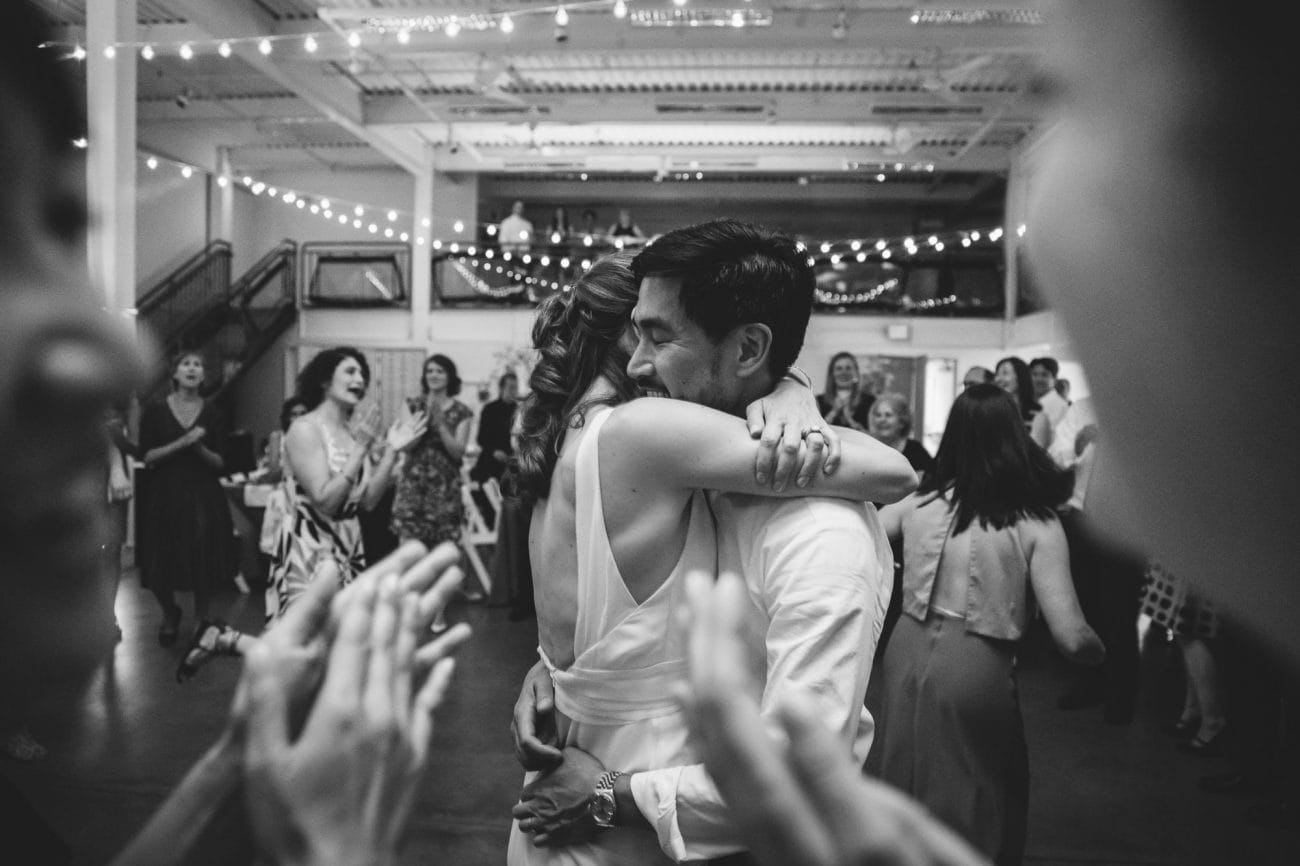 A documentary photograph of a couple hugging on the dance floor during their Artist for Humanity Wedding in Boston