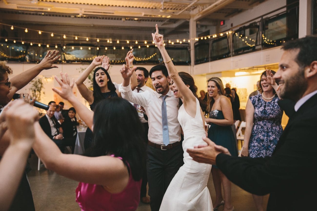 A documentary photograph a bride and groom dancing with their guests at an Artists for Humanity Wedding in Boston
