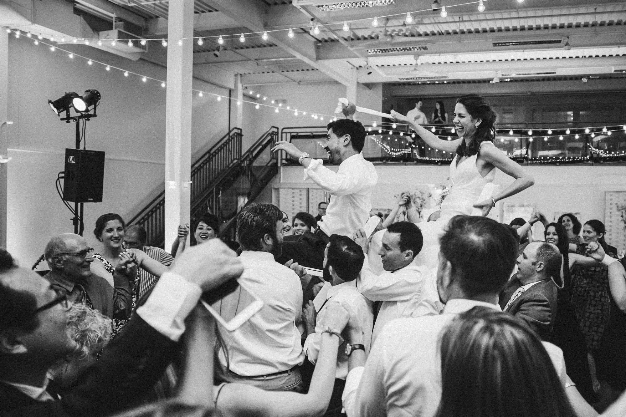 A documentary photograph of the bride and groom in the Hora at their Artists for Humanity Wedding in Boston, Massachusetts