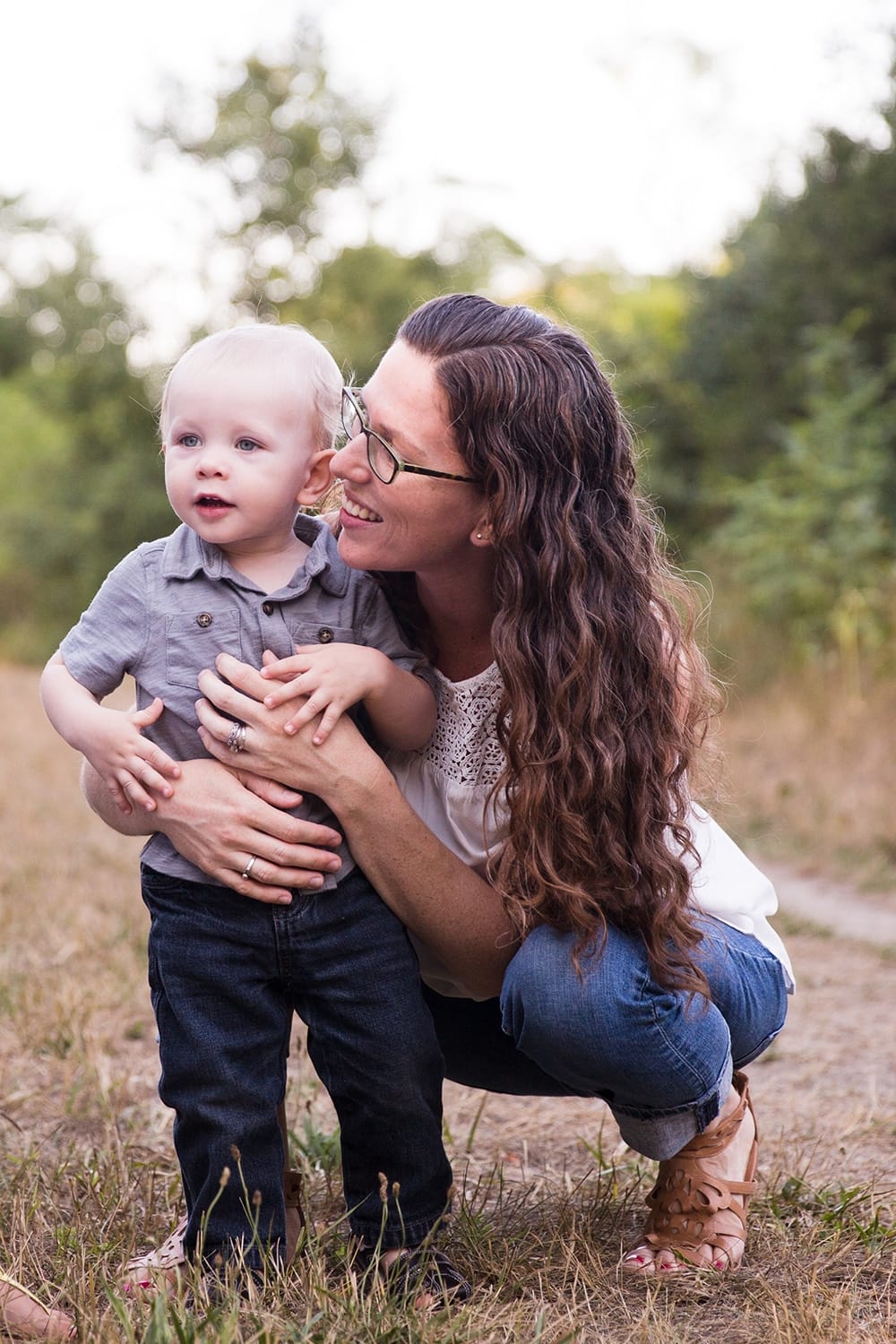 A documentary photograph of a mom hugging her son during an Arnold Arboretum Family Session in Boston, Massachusetts