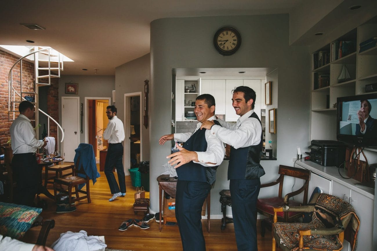 A documentary photograph of two groomsmen getting ready for their friend State Room Wedding in Boston, Massachusetts
