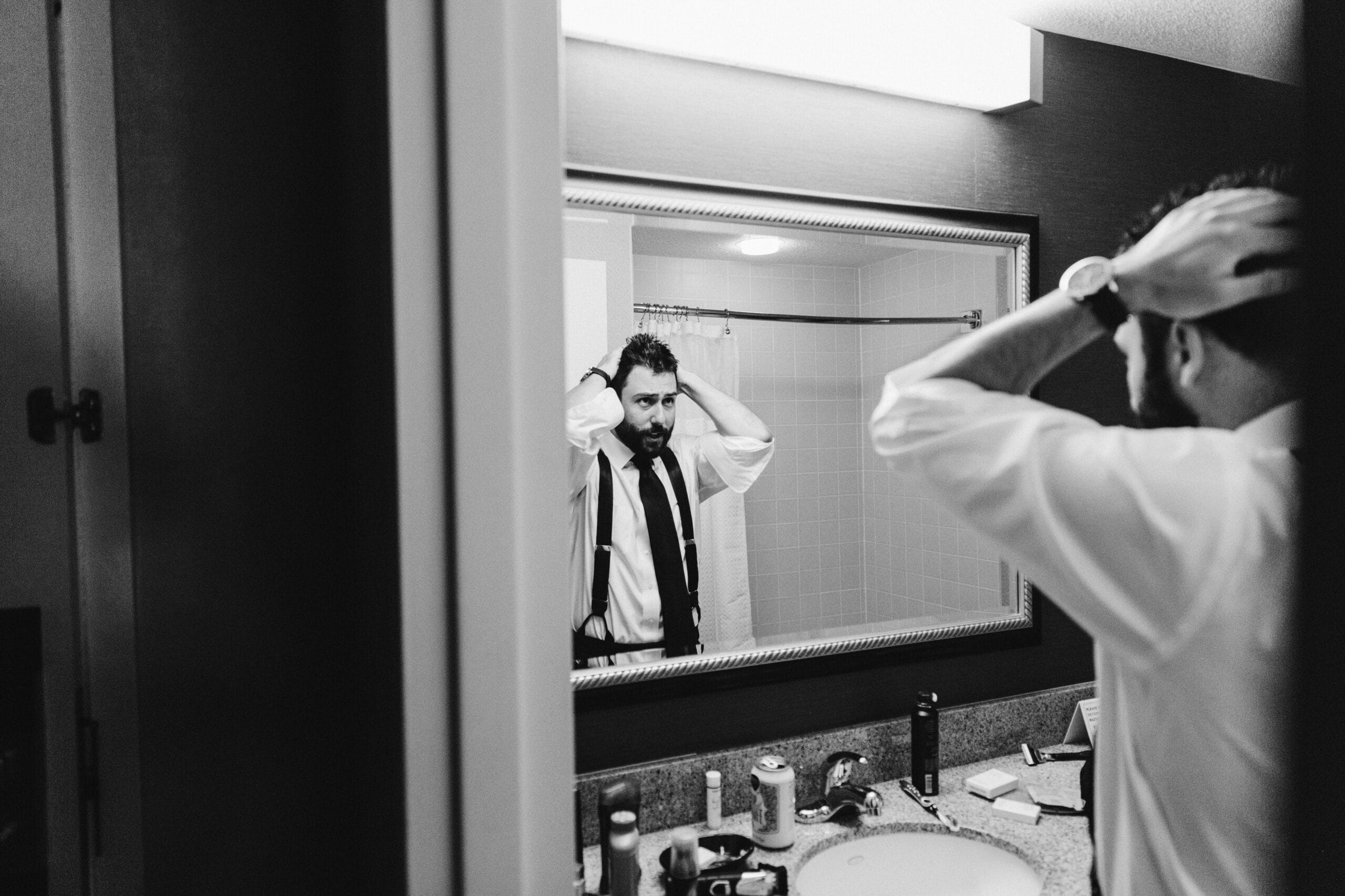 A documentary photograph of a groom getting ready for a moraine farm wedding in Beverly, Massachusetts