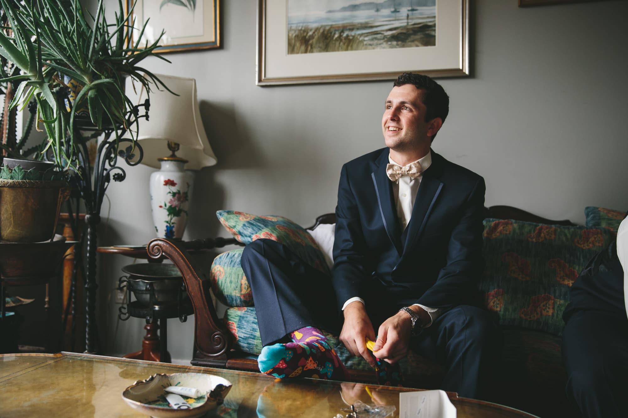 A documentary photograph of the best man smiling with the Groom before a State Room Wedding in Boston, Massachusetts