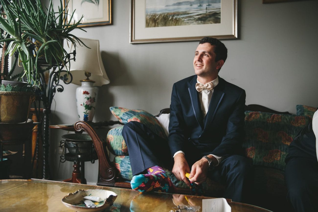 A documentary photograph of the best man smiling with the Groom before a State Room Wedding in Boston, Massachusetts