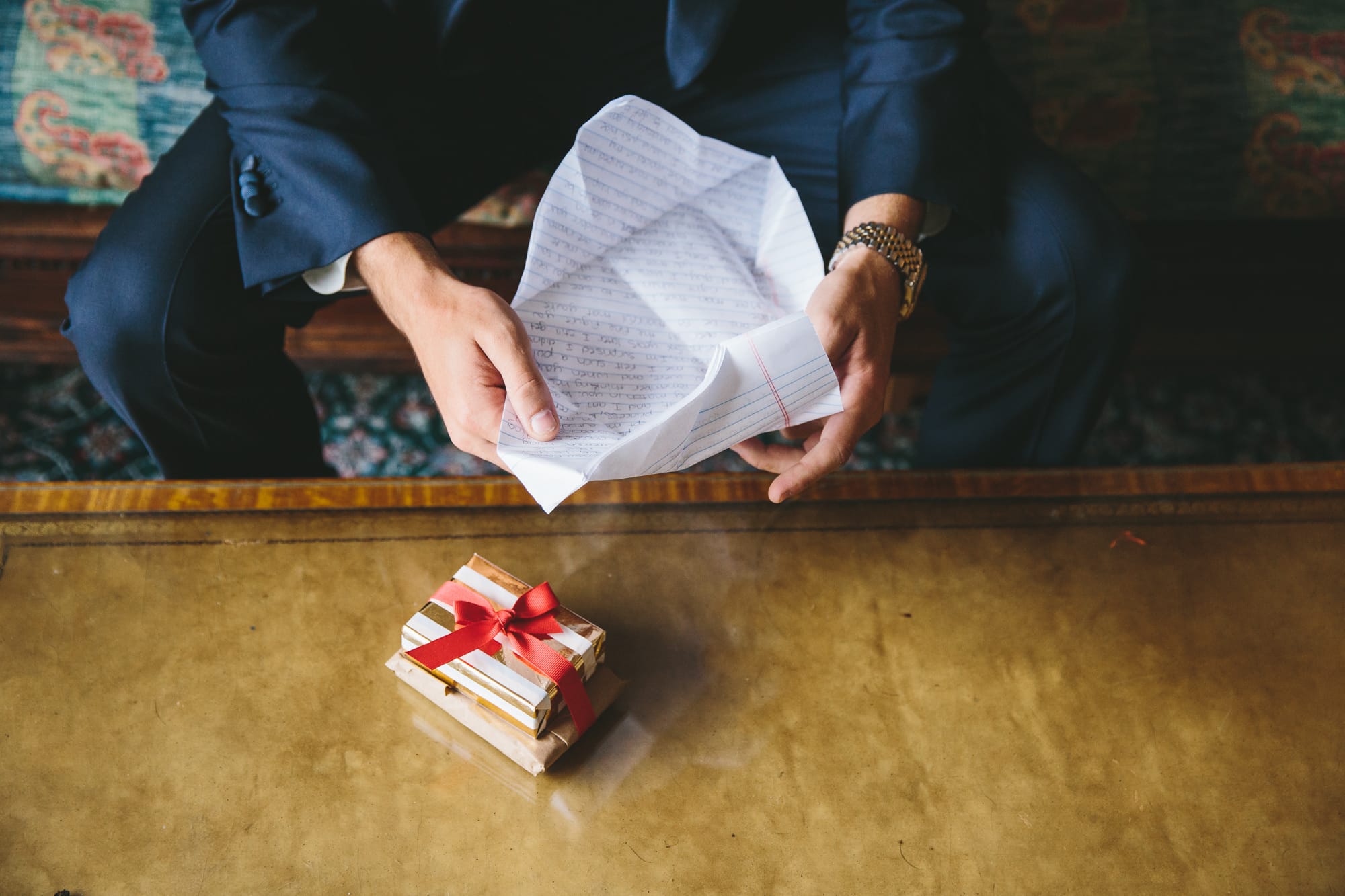 A documentary photograph a groom opening a letter from his bride before their State Room Wedding in Boston, Massachusetts