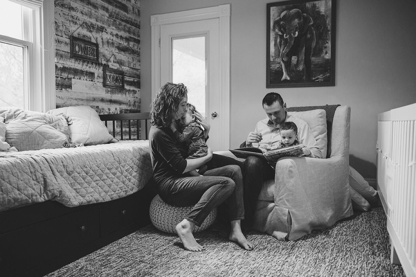 A documentary photograph of twin boys being snuggled by their parents during an in home family session in Boston, Massachusetts