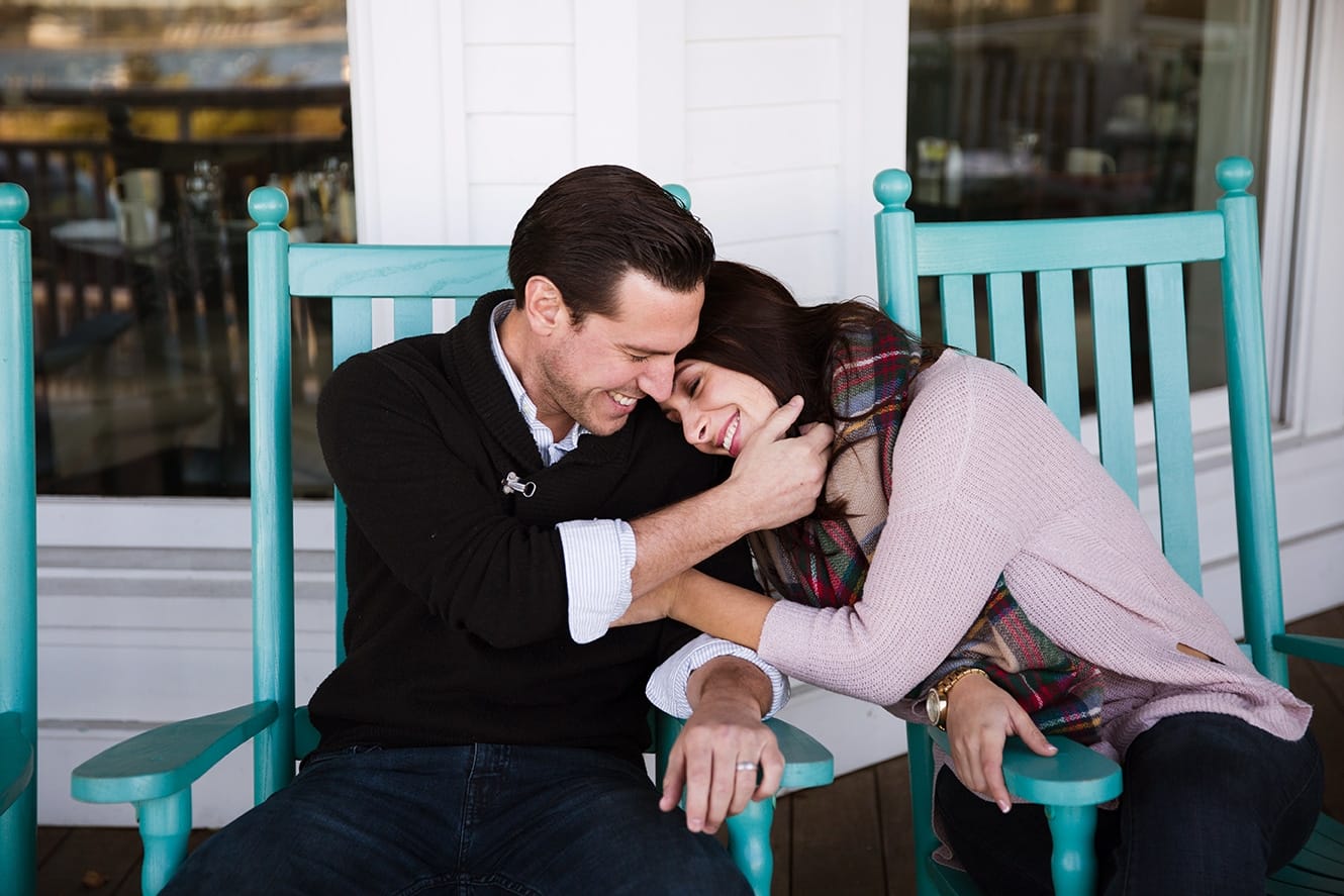 A documentary photograph of a couple snuggling on a porch during their honeymoon photo session on Martha's Vineyard