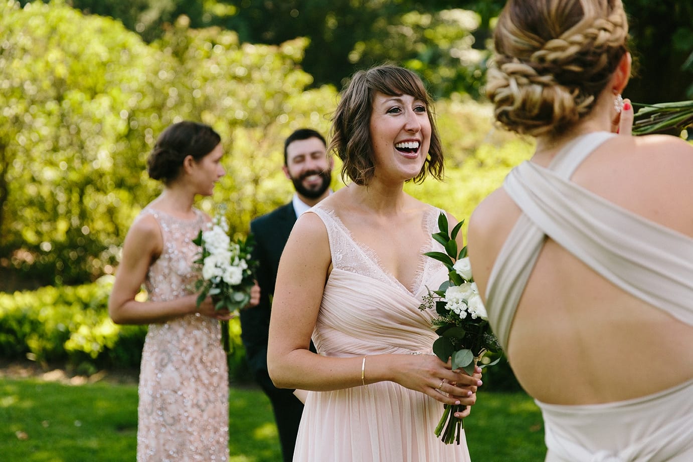 A documentary photograph of a bridesmaid laughing before a Moraine Farm wedding in Beverly, Massachusetts
