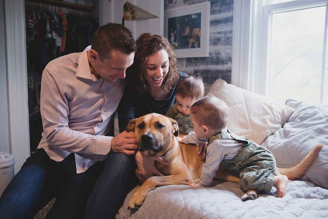 A documentary photograph of a family petting their dog during an in home family session in Boston, Massachusetts