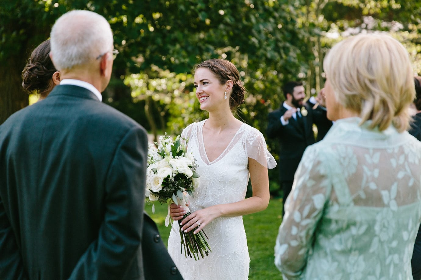A documentary photograph of a bride talking with her family before her Moraine Farm Wedding in Beverly, Massachusetts