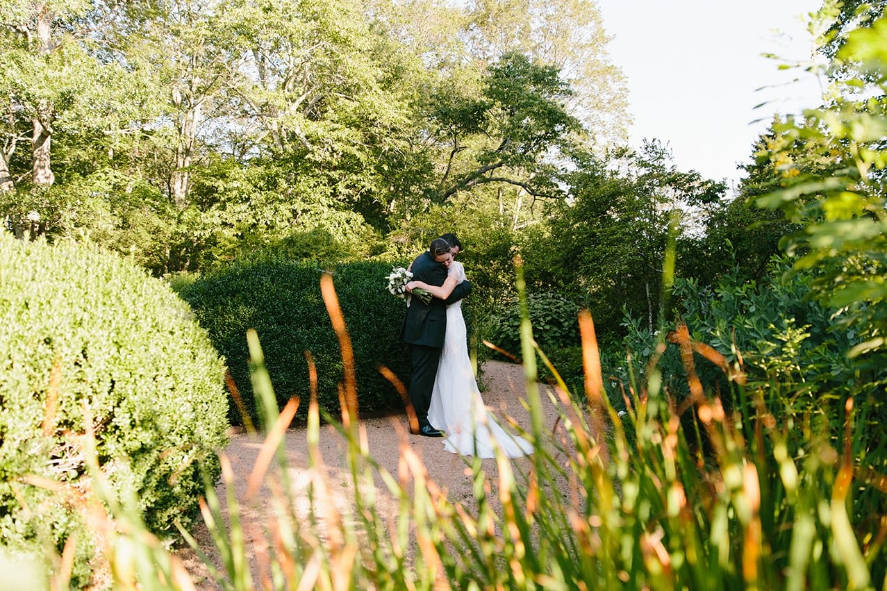 A documentary photograph of a couple hugging after their Moraine Farm Wedding ceremony in Beverly, Massachusetts