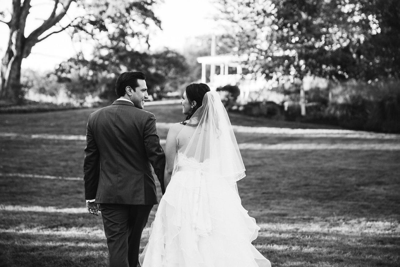 A documentary photograph of a bride and groom walking together during their Harrington Farm Wedding in Princeton, Massachusetts