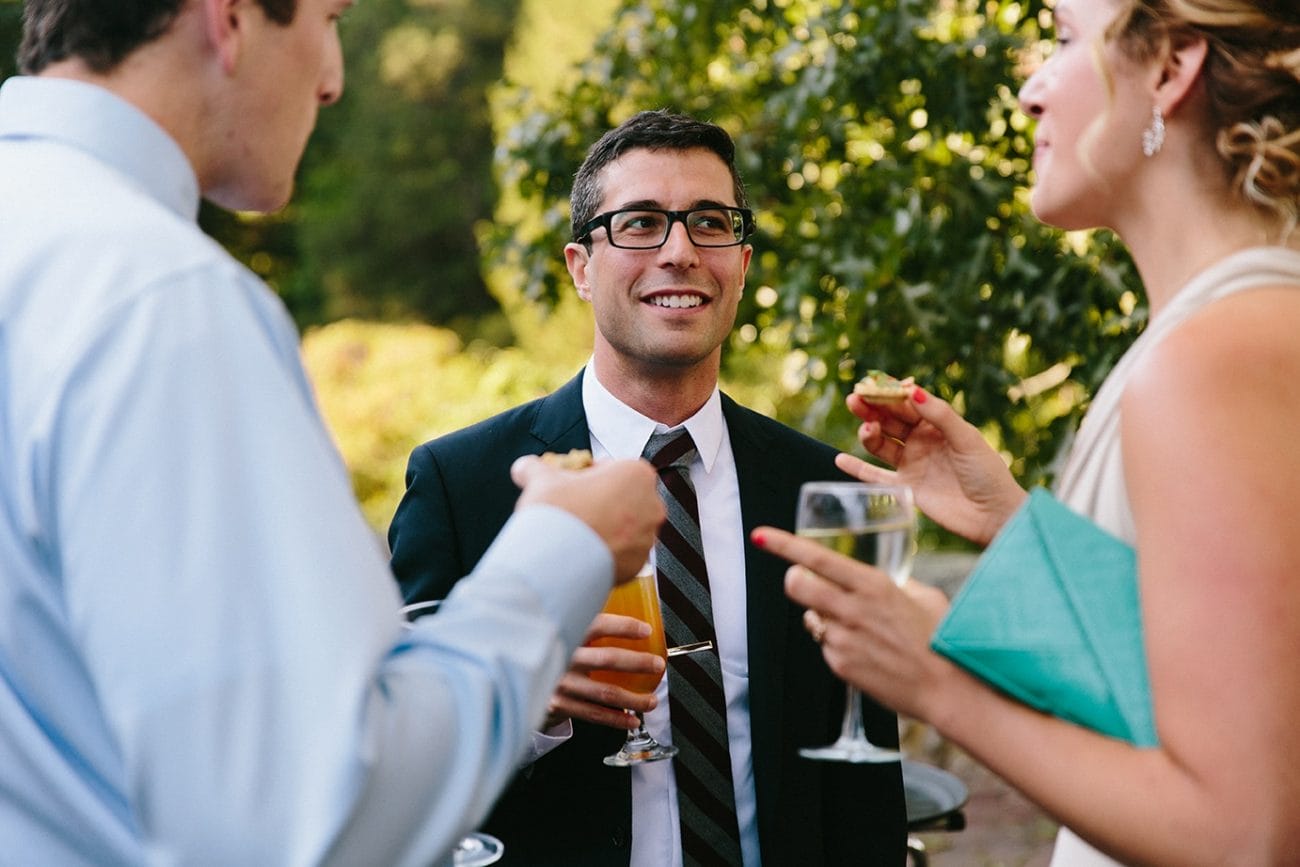 A documentary photograph of guests talking during a Moraine Farm Wedding in Beverly, Massachusetts