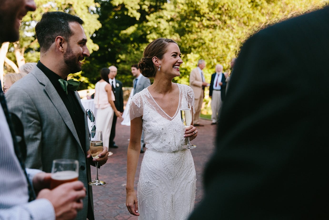 A documentary photograph of guests laughing during a Moraine Farm Wedding in Beverly, Massachusetts