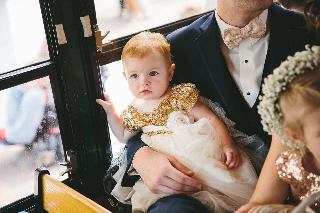 A documentary photograph of a flower girl riding the trolley during a State Room Wedding in Boston, Massachusetts