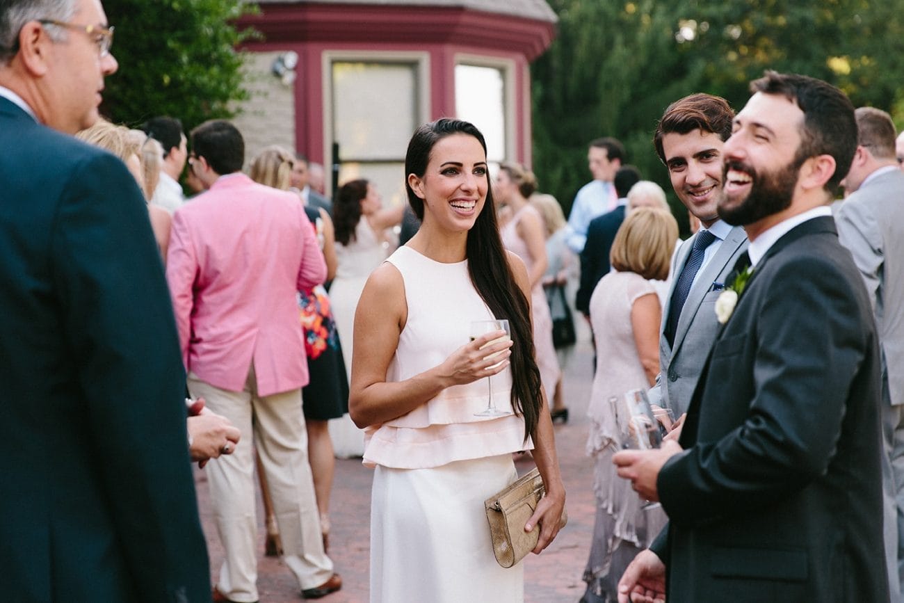 A documentary photograph of guests talking and laughing during a Moraine Farm Wedding in Beverly, Massachusetts