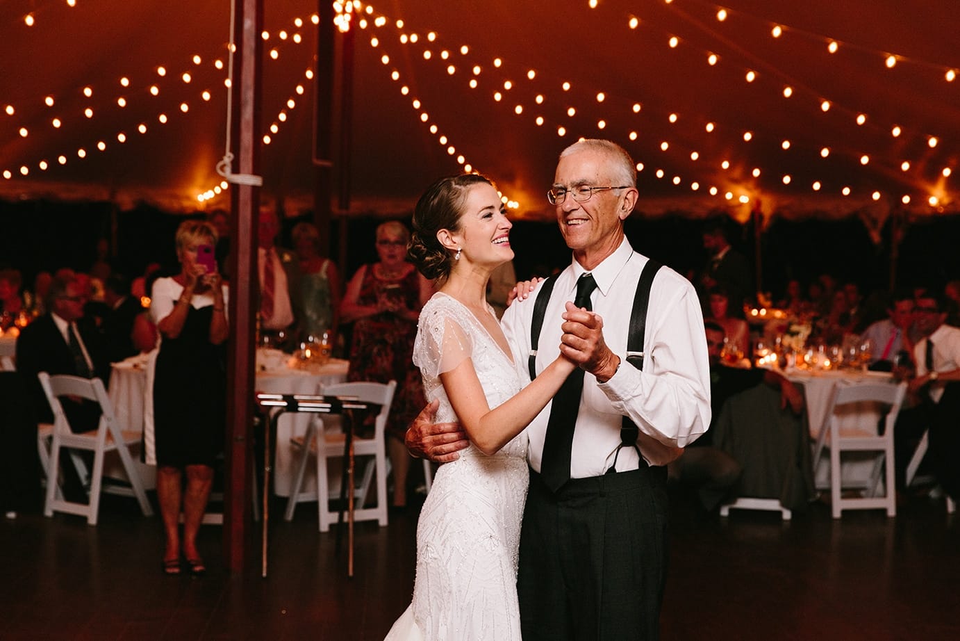 A documentary photograph of a bride dancing with her father during her Moraine Farm Wedding in Beverly, Massachusetts