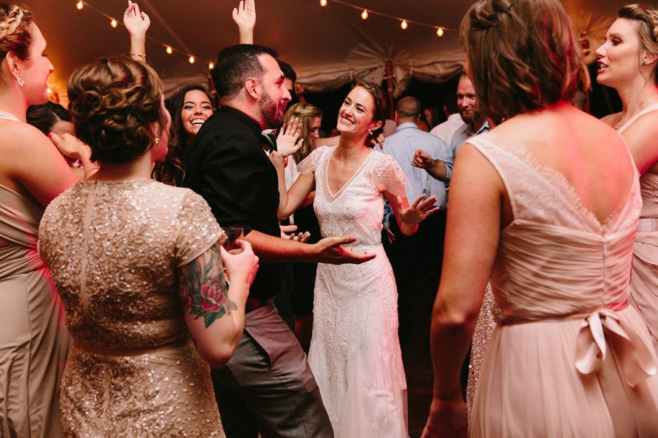 A documentary photograph of a bride dancing with her guests during her Moraine Farm Wedding in Beverly, Massachusetts