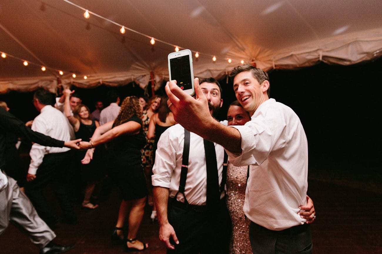 A documentary photograph of a groom taking a selfie with his best man during his Moraine Farm Wedding in Beverly, Massachusetts
