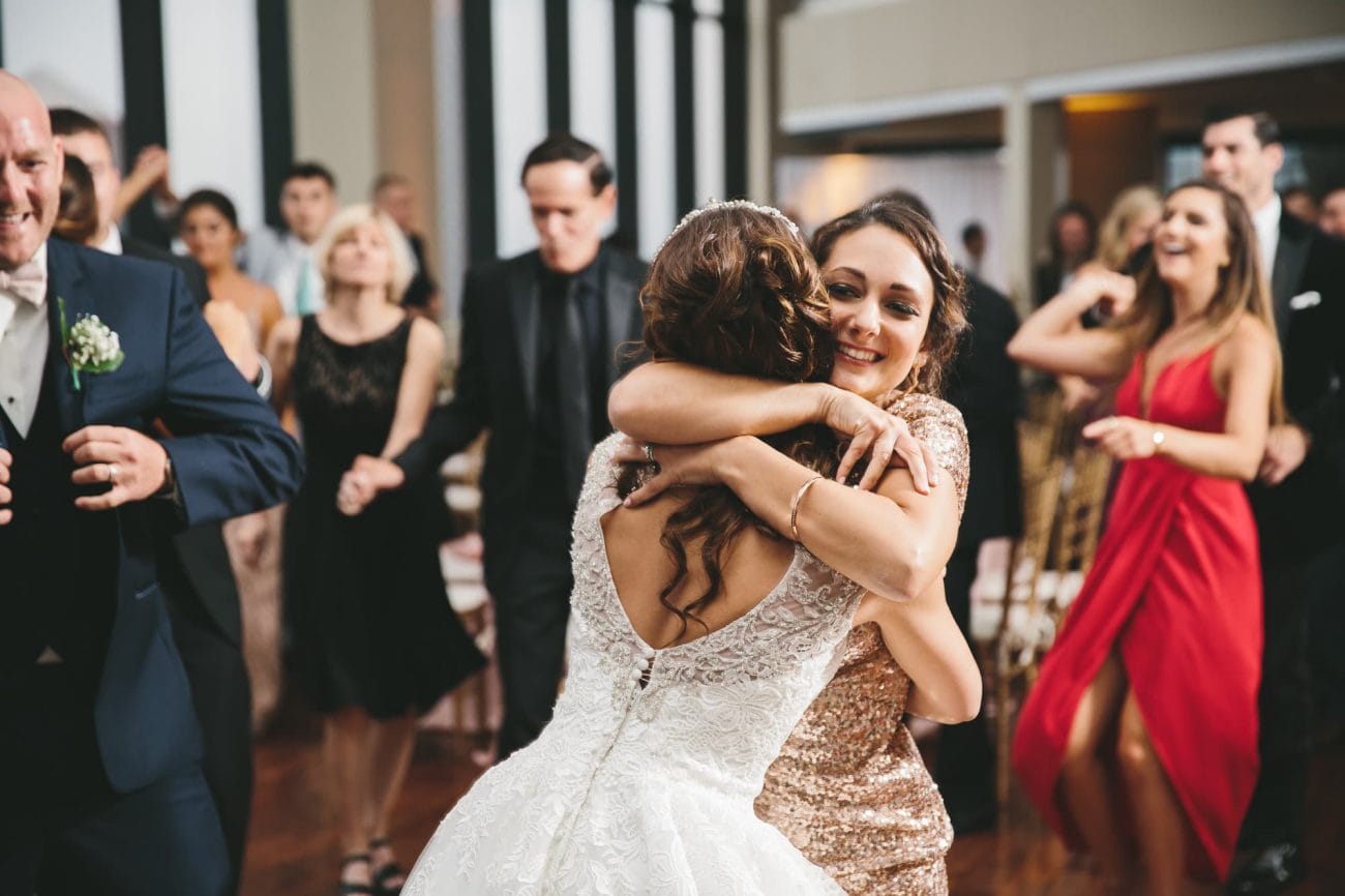A documentary photograph of a bride hugging her sister during her State Room Wedding in Boston, Massachusetts
