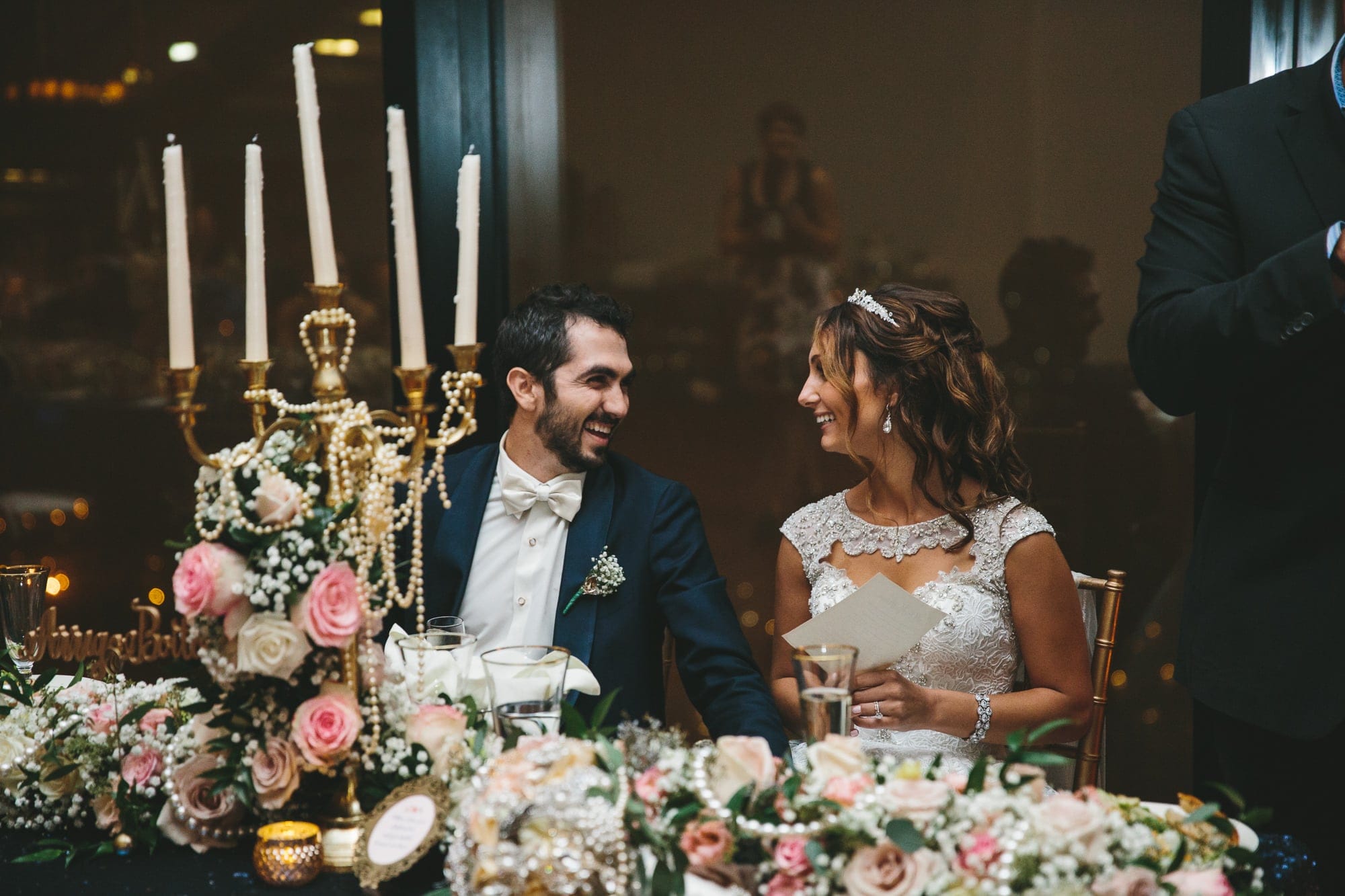A documentary photograph of a couple laughing during their toast at their State Room Wedding in Boston, Massachusetts