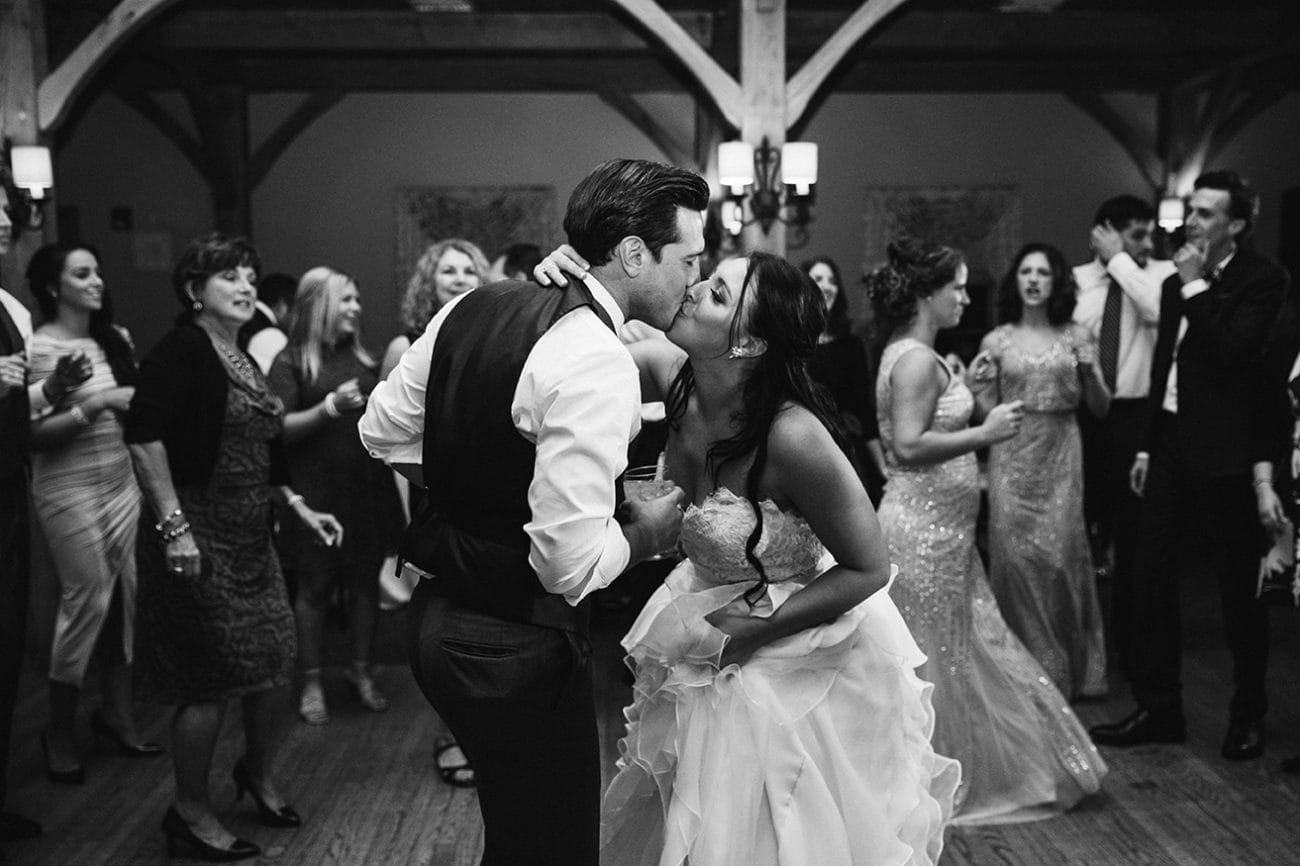 A documentary photograph of a bride and groom kissing on the dance floor during their Harrington Farm Wedding in Princeton, Massachusetts