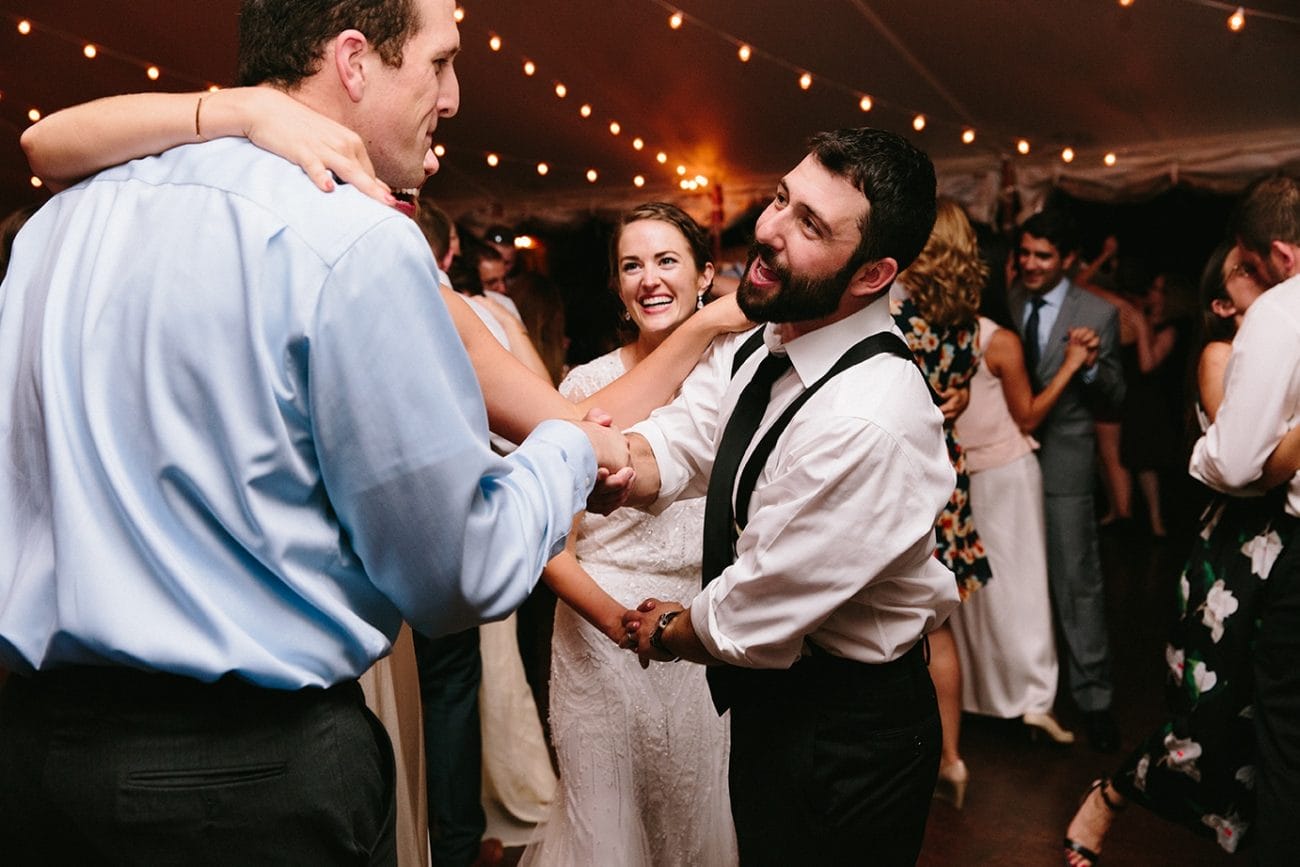A documentary photograph of groom shaking his guest hand during a Moraine Farm Wedding reception in Beverly, Massachusetts