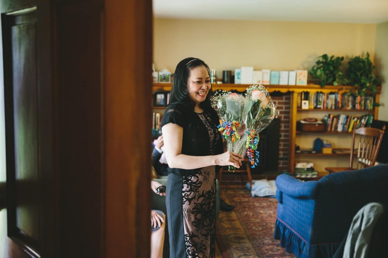 A documentary photograph of the mother of the bride bringing in flowers for their tower hill wedding in Boylston, Massachusetts