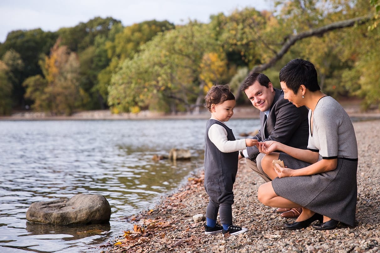 A documentary photograph of a toddler getting bread for ducks during a Jamaica Pond family photo session in Boston