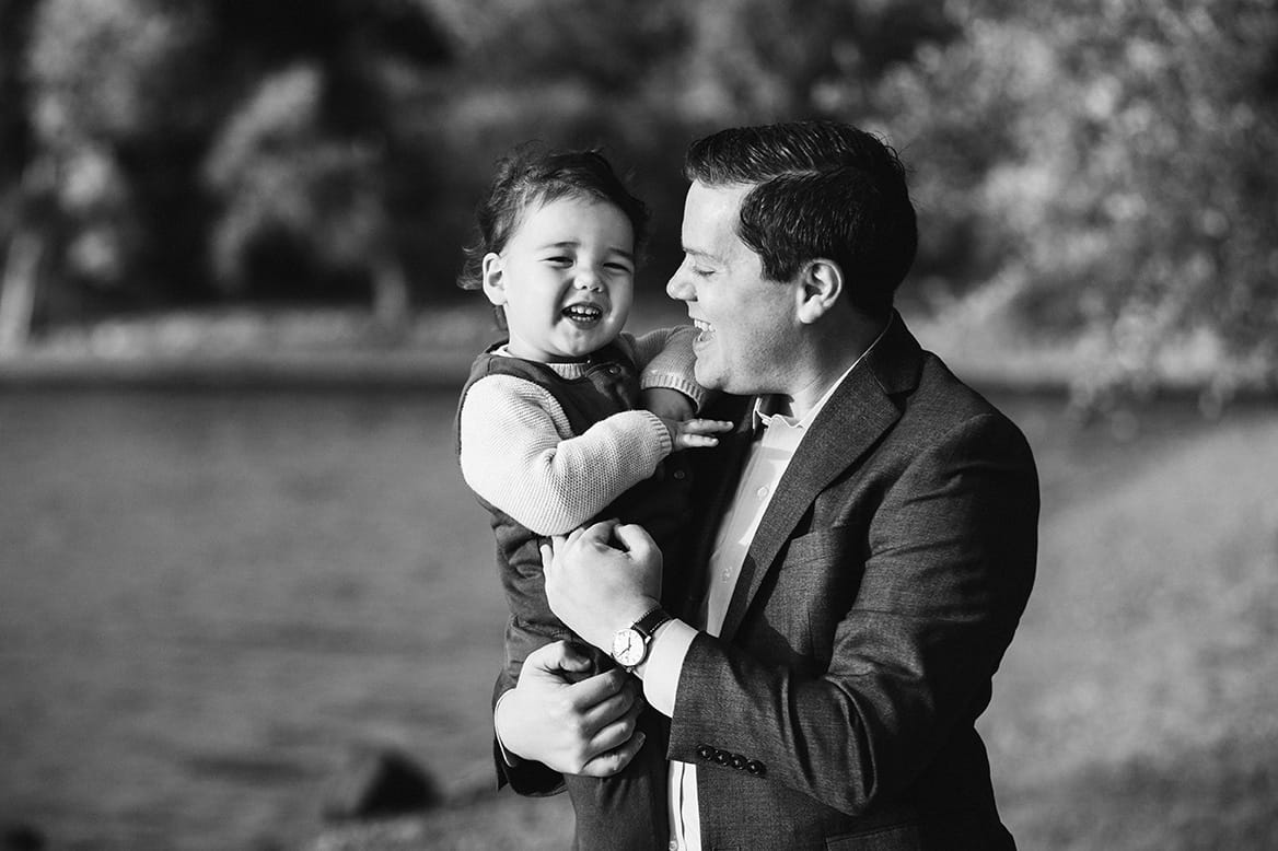 A documentary photograph of a father and son laughing during their Jamaica Pond Family Photo Session in Boston
