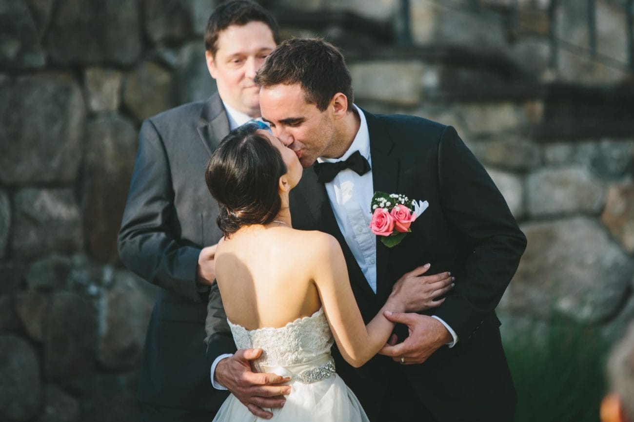 A documentary photograph of a bride and groom sharing a kiss during their Tower Hill Wedding ceremony in Boylston, Massachusetts