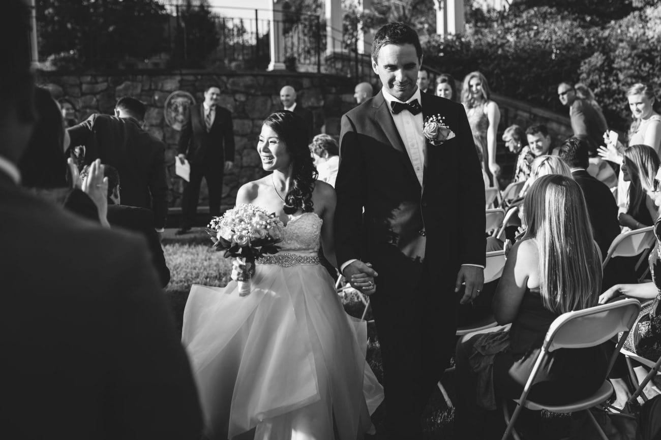 A documentary photograph of a couple walking down the aisle after their Tower Hill Wedding Ceremony in Boylston, Massachusetts