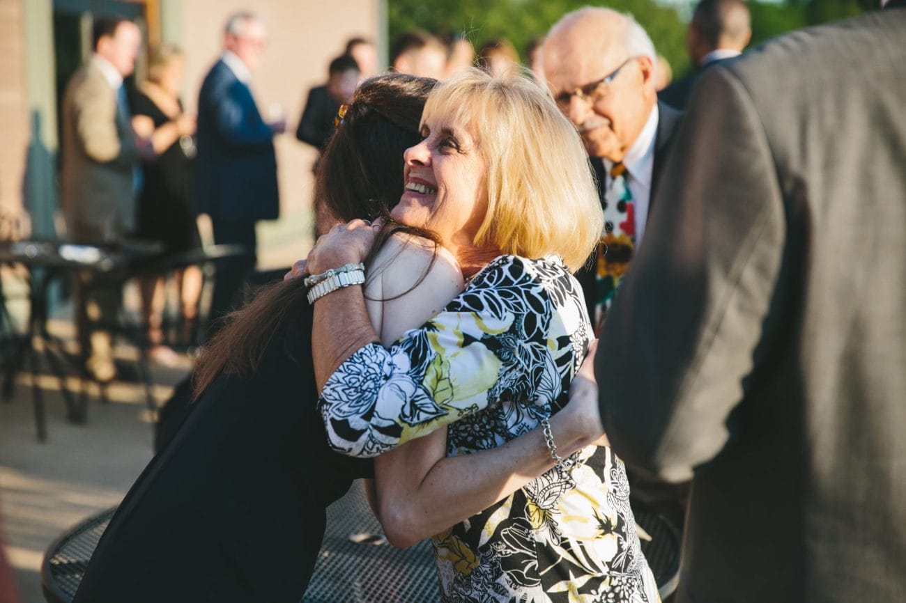 A documentary photograph of guests hugging during a Tower Hill Wedding in Boylston, Massachusetts
