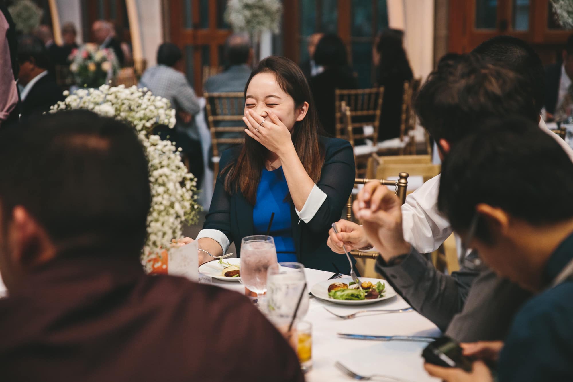 A documentary photograph of a girl laughing during a Tower Hill Wedding reception in Boylston, Massachusetts