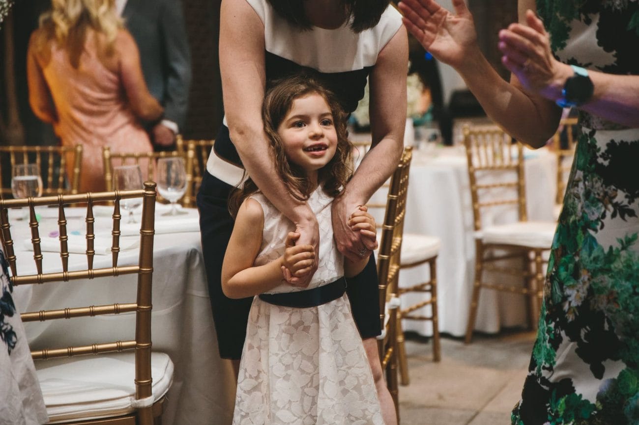 A documentary photograph of a little girl watching guests dance at at Tower Hill Wedding reception in Boylston, Massachusetts