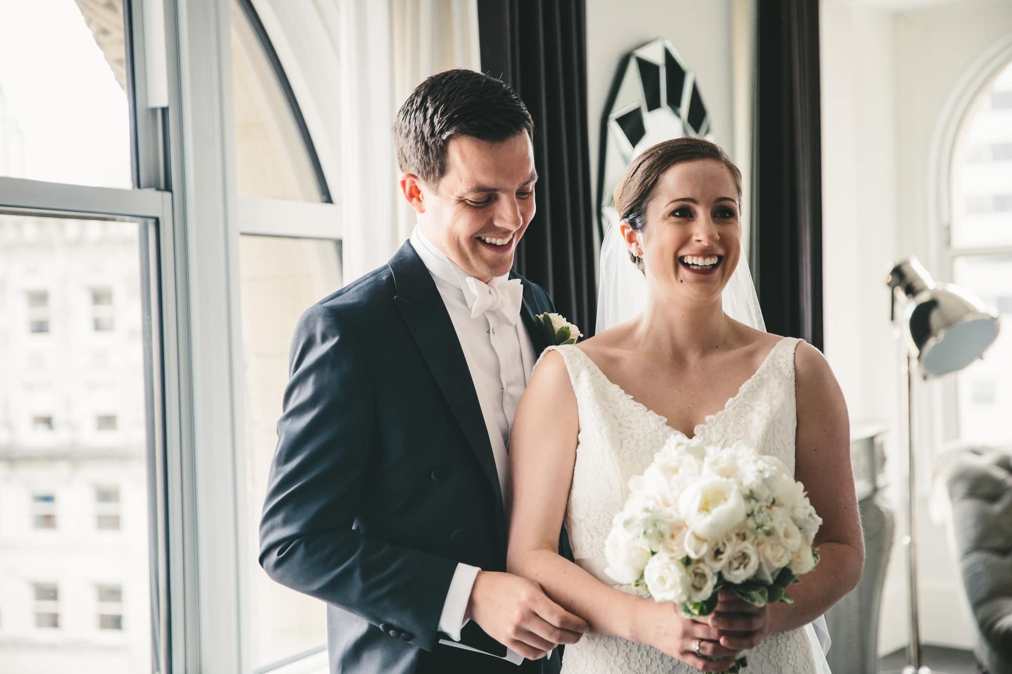 A documentary photograph of a bride and groom seeing each other at the Ames Hotel before their State Room Wedding