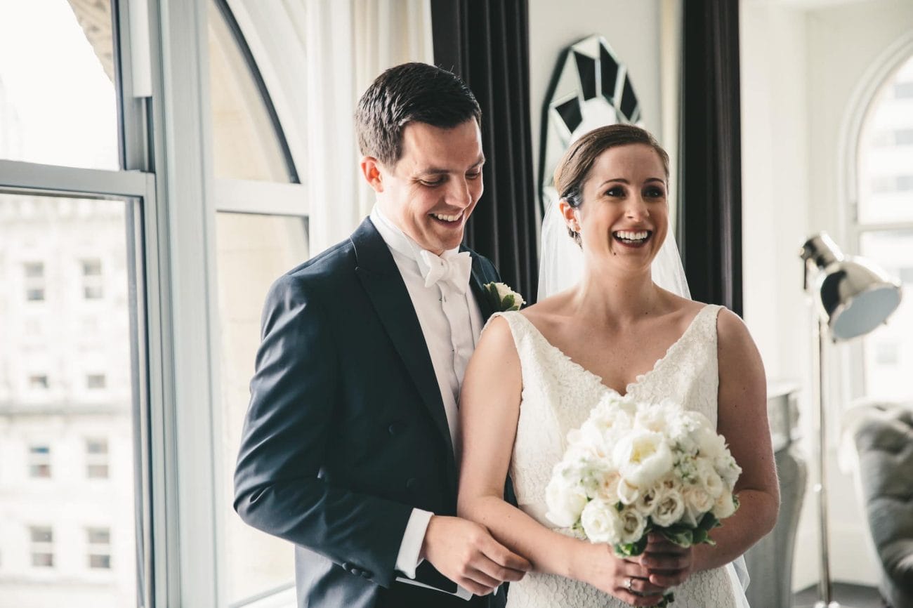 A documentary photograph of a bride and groom seeing each other at the Ames Hotel before their State Room Wedding