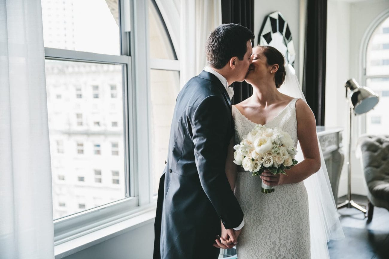 A documentary photograph of a couple kissing at the Ames Hotel before their State Room Wedding