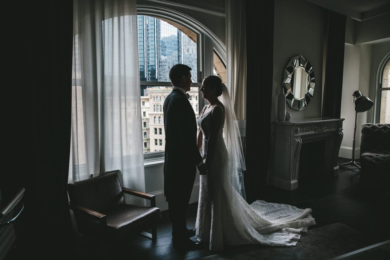 A portrait of a bride and groom seeing each other at the Ames Hotel before their State Room Wedding 