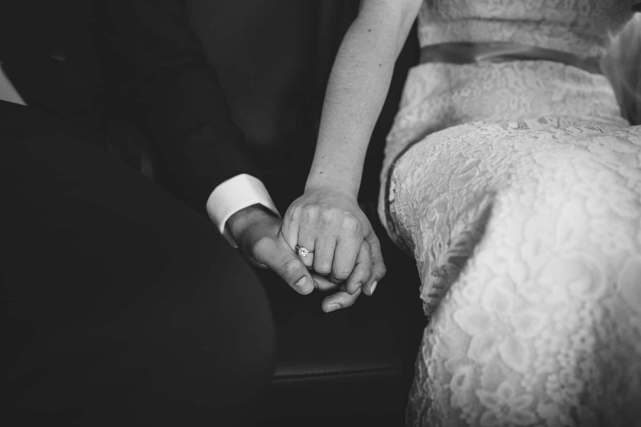 A documentary wedding of a bride and groom holding hands on the way to their wedding ceremony at the old south meeting house before their State Room Wedding reception