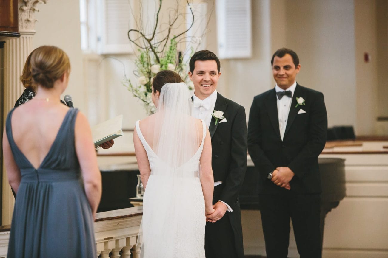 A documentary photograph of a groom smiling during his wedding ceremony at the old south meeting house in Boston, Massachusetts