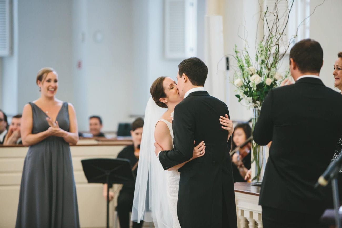 A documentary photograph of a bride and groom sharing a kiss as husband and wife during their old south meeting house wedding ceremony in Boston, Massachusetts