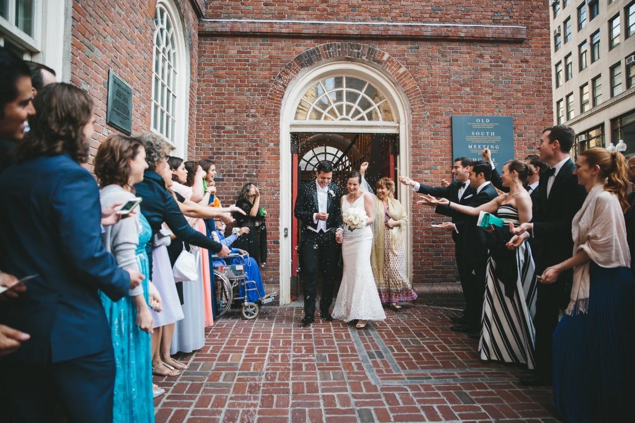 A documentary photograph of a bride and groom leaving the old south meeting house after their wedding ceremony